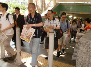 大埔地鐵站外,大清早市民排隊拿免費報紙。 陳姿含攝